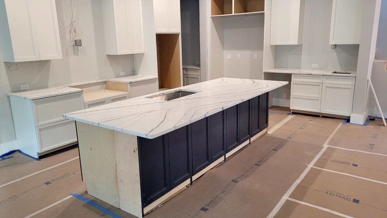 Calacatta quartz kitchen island with navy cabinets — new construction